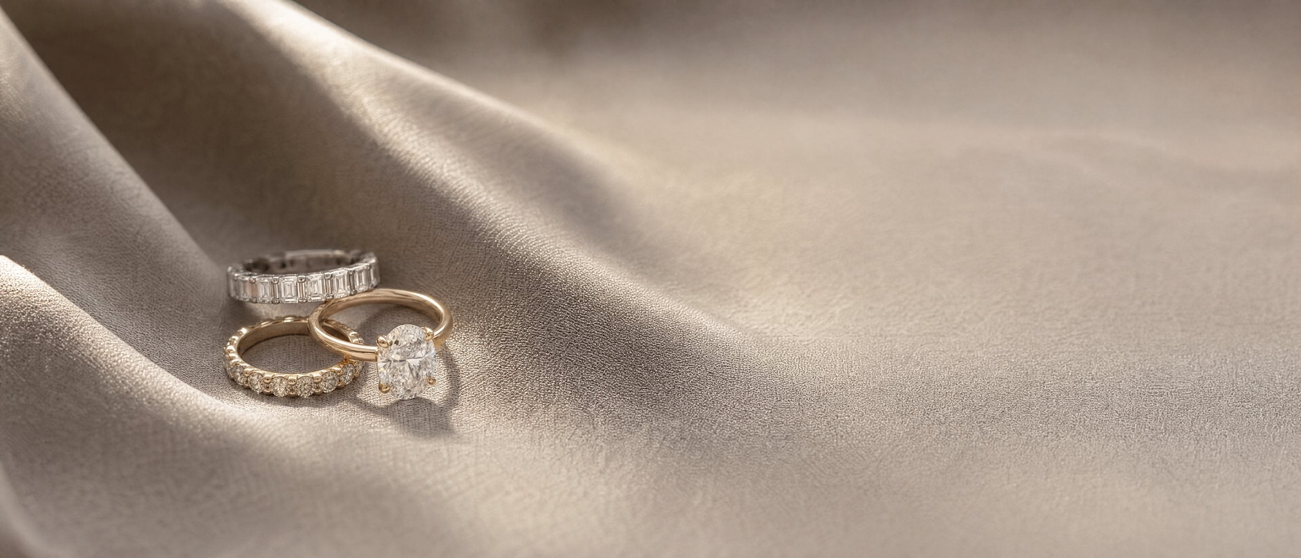 Three rings resting on softly draped silk